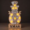 Rozsvícený dřevěný sněhulák XMAS za šera